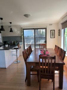 Una cocina y un comedor con mesa y sillas de madera. en Capel Breeze, en Capel Sound