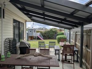 un patio con mesa, sillas y toldo en Capel Breeze, en Capel Sound 6 fotos más