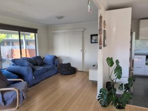 sala de estar con sofá azul en Capel Breeze, en Capel Sound