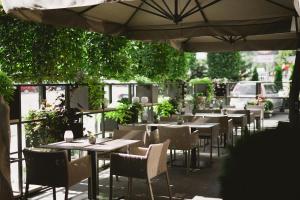 a restaurant with tables and chairs and an umbrella at BERDS Chisinau Mgallery Hotel Collection in Chişinău