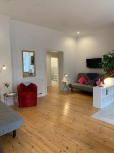 a living room with a couch and a red chair at Ferienwohnung Wethmüller in der Altstadt in Rinteln