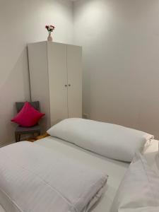 a bedroom with a white bed and a white cabinet at Ferienwohnung Wethmüller in der Altstadt in Rinteln