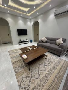 a living room with a couch and a coffee table at New Time Apartments in Al-ʿUla