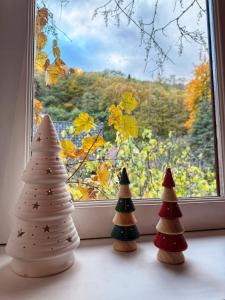 three decorated christmas trees sitting in front of a window at Chez l'Alsacienne in Andlau +7 photos