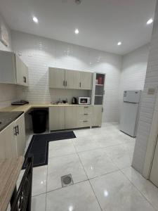 a kitchen with a refrigerator and a stove at New Time Apartments in Al-ʿUla