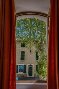 a view of a building through a window at Spacieux Duplex - Lumineux et Calme - Alpilles in Eyguières