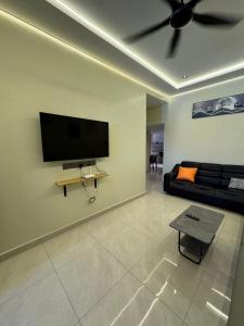 a living room with a couch and a flat screen tv at Spacious Comfort Staycation Homefeel free WIFI TK9 in Ipoh