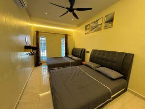 a bedroom with a couch and a ceiling fan at Spacious Comfort Staycation Homefeel free WIFI TK9 in Ipoh
