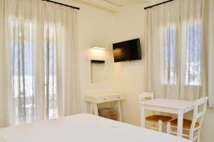 a bedroom with a bed and a table and a tv at Sohoro in Koufonisia