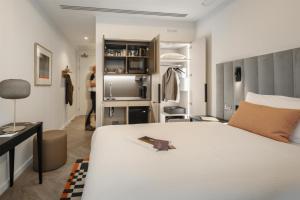 a bedroom with a large white bed and a closet at The Wellington Glasgow by Adina in Glasgow