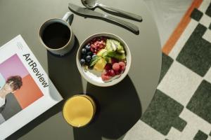 a bowl of fruit on a table next to a book at The Wellington Glasgow by Adina in Glasgow +20 photos