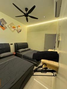a bedroom with two beds and a ceiling fan at Spacious Comfort Staycation Homefeel free WIFI TK9 in Ipoh