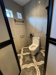 baño con aseo y suelo de baldosa. en Ipoh Spacious Comfort Staycation Homefeel free WIFI TK9, en Ipoh 17 fotos más