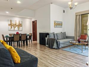 a living room with a couch and a dining room at La Buena Vida Holiday Homes - Modern, Luxe & Spacious 4-Bed, Full Kitchen, near to Beach, Tram & Marina in Dubai