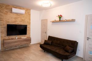 a living room with a couch and a flat screen tv at DowntownKate in Debrecen