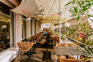 una fila de mesas y sillas con sombrillas en un restaurante en Hotel Kleiner Markt, en Saarlouis