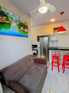 a living room with a couch and a kitchen at Apartamento novo e confortável in Belém