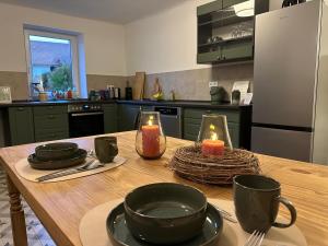 a kitchen with a wooden table with candles on it at Maison de Chasse Karlsbrunn in Großrosseln