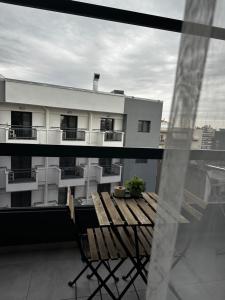 a balcony with a wooden bench on a building at Panthera-urban-studio in Xanthi