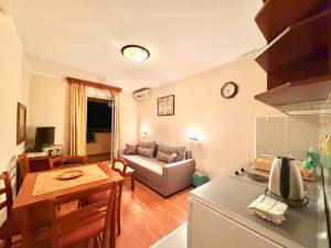 a kitchen and living room with a couch and a table at Beachfront Apartments Oaza in Petrovac na Moru