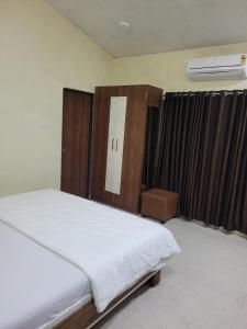 ein Schlafzimmer mit einem Bett mit hölzernem Kopfteil in der Unterkunft Zenzi Stays 11 BHK With 2 Pools in Khandāla