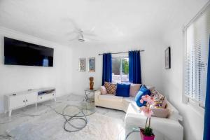 a living room with a couch and a table at Hibiscus Charm in Red Hills