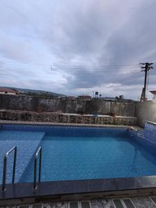 einem großen Pool an der Seite eines Gebäudes in der Unterkunft Zenzi Stays 11 BHK With 2 Pools in Khandāla + 21 Fotos