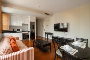 een woonkamer met een bank en een tafel bij Smartmonki Sinagoga Entre la Catedral y Zocodover in Toledo