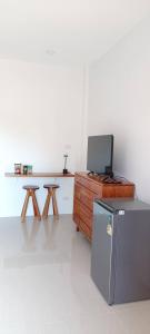 a room with a table with a laptop on top of a refrigerator at Vaplanakhaw Ubon in Ubon Ratchathani