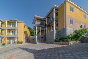a yellow building with a brick driveway in front of it at Hibiscus Charm in Red Hills