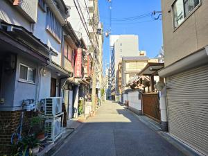 an empty alley way with buildings on either side at 新大阪ゲストハウス 新大阪駅徒歩5分のリノベーション貸切宿 in Osaka