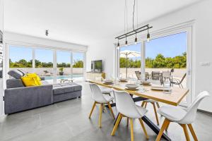 a dining room with a table and a couch at Villa Karolina by Villa Plus in Štokovci