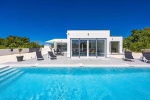 a swimming pool in front of a house at Villa Karolina by Villa Plus in Štokovci