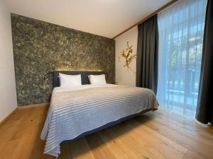 ein Schlafzimmer mit einem großen Bett und einem großen Fenster in der Unterkunft Gemmi Hotel & Spa in Kandersteg
