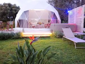 a room in a dome tent in a yard with chairs at La Fontana Glamping in Caria