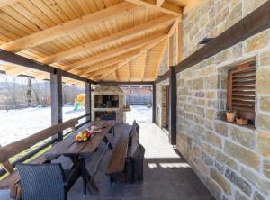 patio esterno con tavolo e parete in pietra di Lovinac Spa by Režek a Lovinac