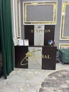 サマルカンドにあるHotel Global Starの緑のカーテンがかかった部屋にある、看板が置かれたテーブル