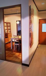 a dining room with a table and a mirror at HYGGE HOUSE Tabibitonoie - Vacation STAY 33409v in Kashiwa