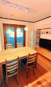 a dining room with a table and chairs and a television at HYGGE HOUSE Tabibitonoie - Vacation STAY 33409v in Kashiwa