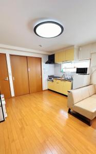 a living room with a couch and a kitchen at HYGGE HOUSE Tabibitonoie - Vacation STAY 61173v in Kashiwa