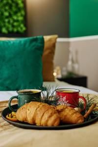 a plate of bread and two cups on a table at Aparthotel Green Concrete in Świnoujście