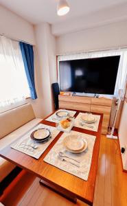 a table with plates of food on it with a television at HYGGE HOUSE Tabibitonoie - Vacation STAY 61173v in Kashiwa