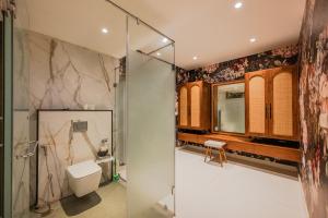 a bathroom with a toilet and a glass shower at Bangalore Bubble Stay 1BHK Villa - Bella in Denkanikota +5 photos