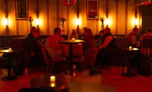 a group of people sitting at tables in a restaurant at Hotel Gotham Newcastle in Newcastle upon Tyne