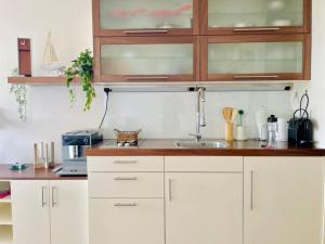 a kitchen with white cabinets and a sink at Penthaus Horizont mit Meerblick in Lübeck +20 photos