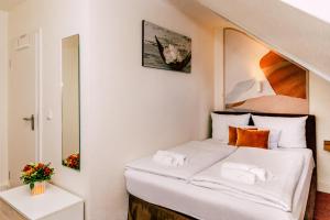 Una pequeña habitación con una cama y un espejo. en Hotel Kleiner Markt, en Saarlouis