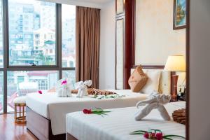 a hotel room with two beds with white towels on them at Thai Ha Hotel in Ha Long +36 photos
