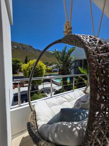 Hermanus Manor في هيرمانوس: كرسي أرجوحة الخوص على شرفة مطلة