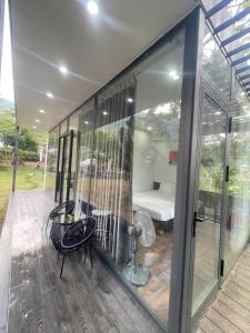 a large glass building with a room with a bedroom at Mường Dy Retreat 2 in Ba Vì