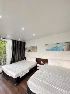 a bedroom with two beds and a window at Mường Dy Retreat 2 in Ba Vì